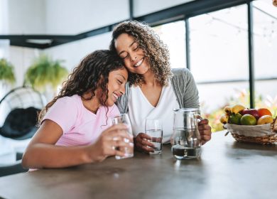 Mother and daughter drinking water together